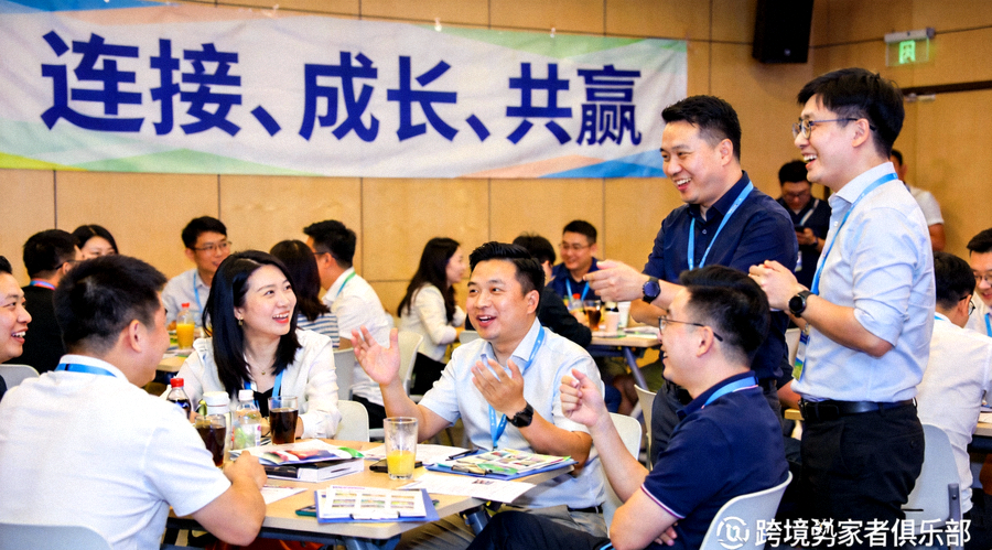 跨境卖家俱乐部线下资源对接会现场，众多卖家正在热烈交流，背景是写有‘连接、成长、共赢’的横幅